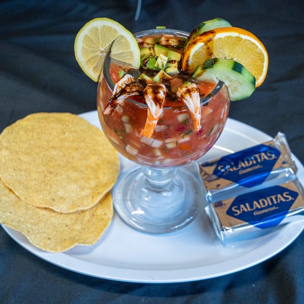 A Salvadoran shrimp cocktail with avocado, lemon, orange, and cucumber, served with tostadas and crackers.